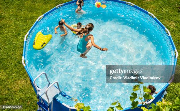 kids enjoying splashing in swimming pool - staycation pool stock pictures, royalty-free photos & images