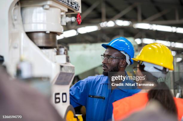 female engineer and operator technical testing program a cnc milling machine in a foundry industry. - black jumpsuit stock pictures, royalty-free photos & images