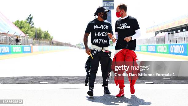 Lewis Hamilton of Great Britain and Mercedes GP and Sebastian Vettel of Germany and Ferrari talk on the grid before the F1 Grand Prix of Spain at...