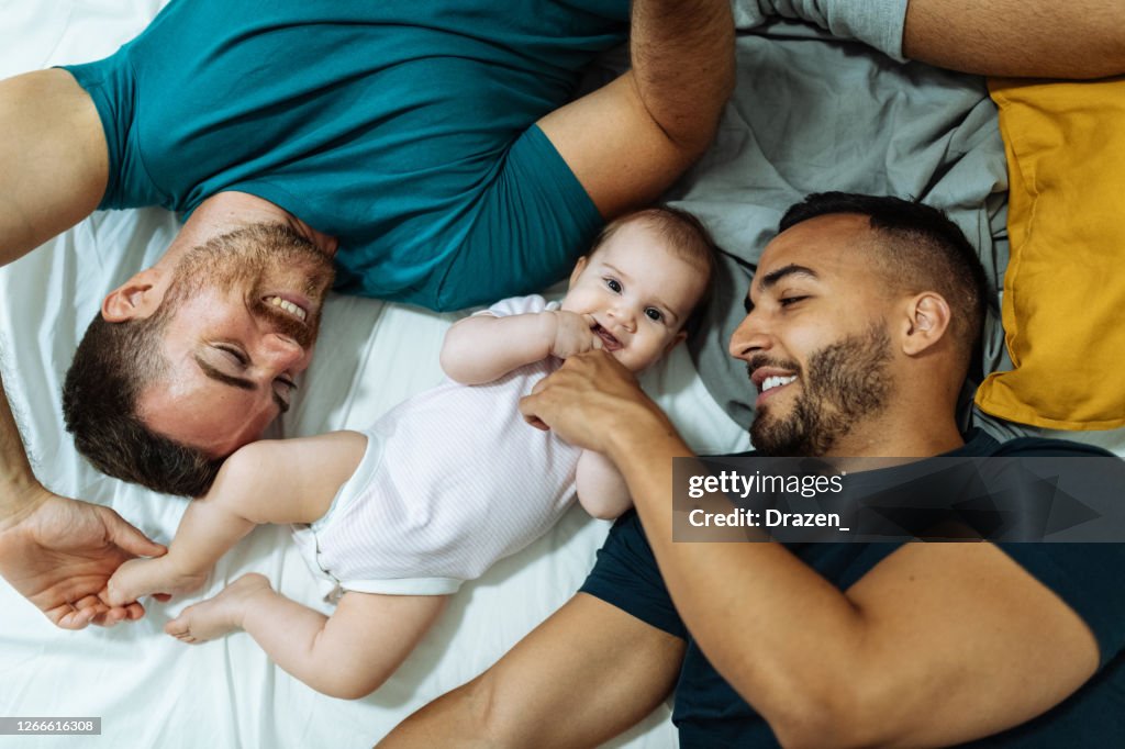 Gay couple and baby girl spending time together during coronavirus