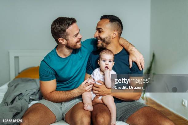 adozione gay - superare le questioni sociali. coppia lgbt con bimba adottata a casa - diritti degli omosessuali foto e immagini stock