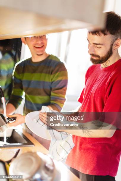 gay couple washing up and having fun - wash the dishes stock pictures, royalty-free photos & images