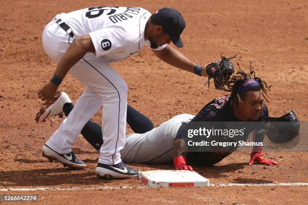 Jose Ramirez of the Cleveland Indians makes it back to first base to beat the tag from Jeimer Candelario of the Detroit Tigers during the third...