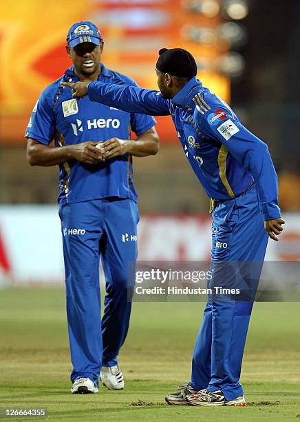 Mumbai Indian's captain, Harbhajan Singh points towards the pavillion as Andrew Symonds looks on during the Champions League Twenty20 Group A match...