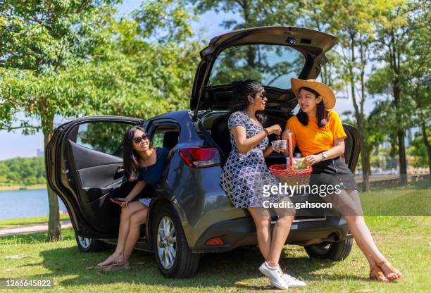 weibliche freunde mit spaß und sprechen mit dem auto - car park stock-fotos und bilder