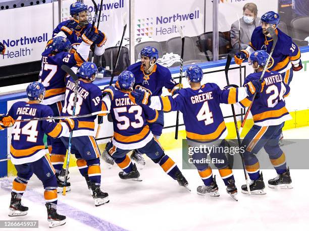 Mathew Barzal of the New York Islanders is congratulated by his teammates after scoring the game winning goal at 4:28 of overtime against the...
