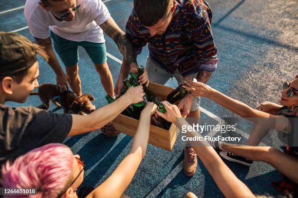 carefree friends taking beer out of a wooden crate on an outdoor party - crate stock pictures, royalty-free photos & images