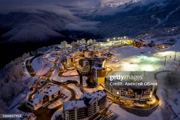 night aerial view of the ski resort rosa khutor. a complex of hotels on the site of the former olympic village of rosa plateau at an altitude of 1170 m from sea level. krasnaya polyana, sochi, russia - krasnaya polyana sochi fotografías e imágenes de stock