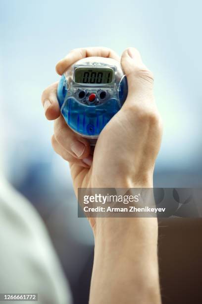 hand of sportsman holding pedometer - mass unit of measurement stock-fotos und bilder