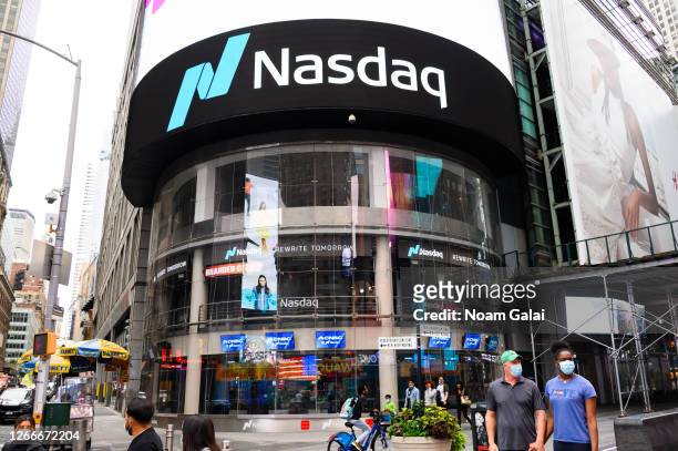 People wear protective face masks outside Nasdaq in Times Square as the city continues Phase 4 of re-opening following restrictions imposed to slow...