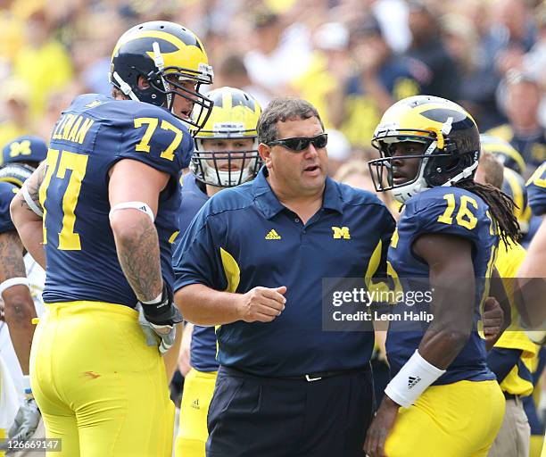 Michigan Wolverines head coach Brady Hoke talks with Taylor Lewan and Denard Robinson during the game against San Diego State at Michigan Stadium on...