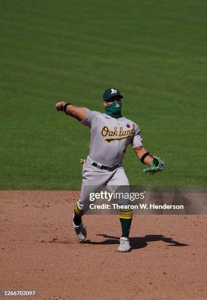 Franklin Barreto of the Oakland Athletics throw to first base throwing out Donovan Solano of the San Francisco Giants in the bottom of the ninth...