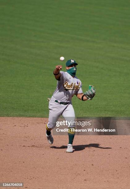 Franklin Barreto of the Oakland Athletics throw to first base throwing out Donovan Solano of the San Francisco Giants in the bottom of the ninth...