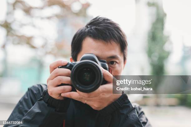 man photographing with dslr - digital single lens reflex camera stock pictures, royalty-free photos & images