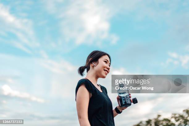 cheerful young woman with water bottle after exercising - 運動　日本人 ストックフォトと画像