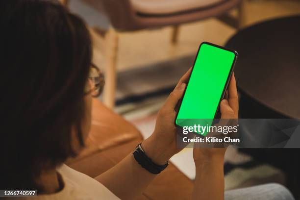 asian woman using a cellphone with chroma key - femme de dos smartphone photos et images de collection