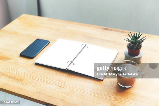 workplace with notepad, coffee and smartphone. - notepad table stockfoto's en -beelden