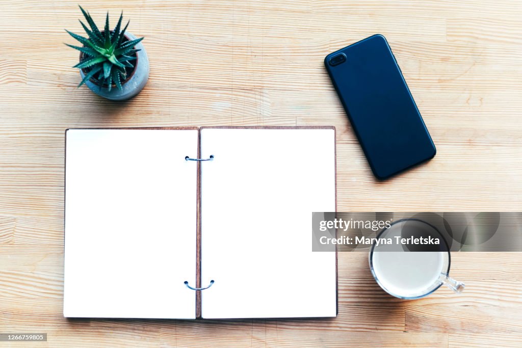 Workplace with notepad, coffee and smartphone.