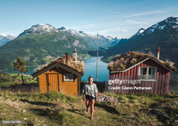 young woman by fjord in norway. - log cabin stock pictures, royalty-free photos & images