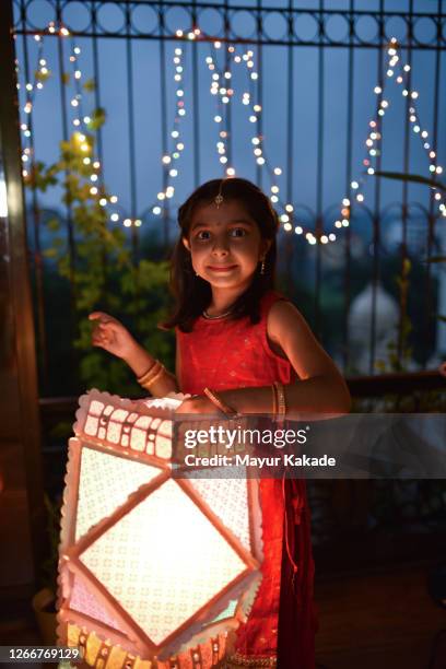 portrait of a girl holding diwali lamp - diwali lantern stock pictures, royalty-free photos & images