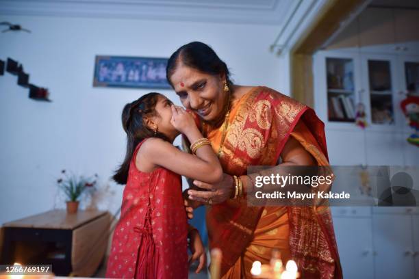 granddaughter sharing a secrete with grandmother - hinduism stock pictures, royalty-free photos & images