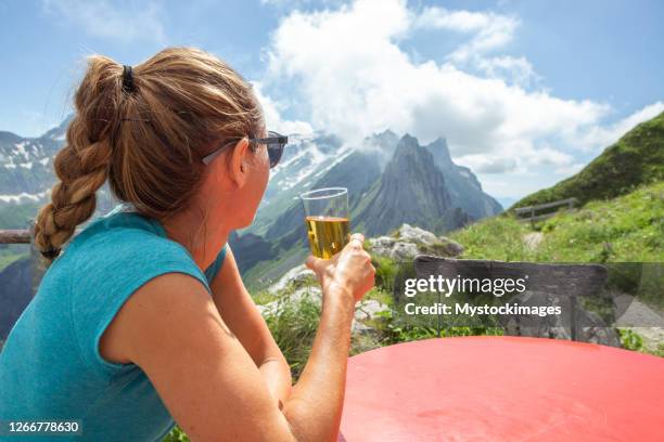 woman enjoying drink from mountain hut - hut mountains stock pictures, royalty-free photos & images