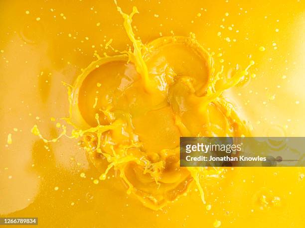 orange juice splash - colour image stock-fotos und bilder