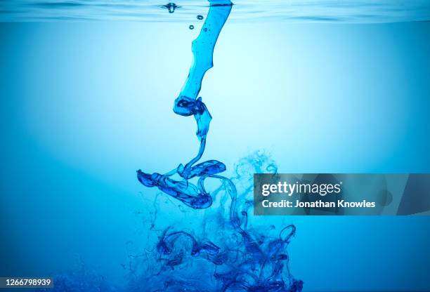 blue liquid underwater - squirting foto e immagini stock