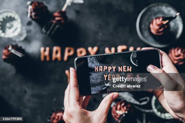 frau fotografiert flache legende neujahrskekse - silvester berlin stock-fotos und bilder