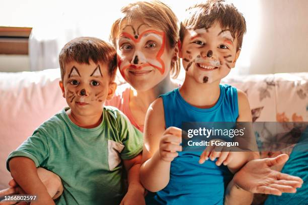 mamá y los niños pasan tiempo divertido en casa durante los días de cuarentena - pintura de cara fotografías e imágenes de stock