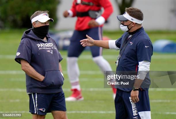 Head coach Bill Belichick of the New England Patriots talks with offensive coordinator Josh McDaniels during training camp at Gillette Stadium on...