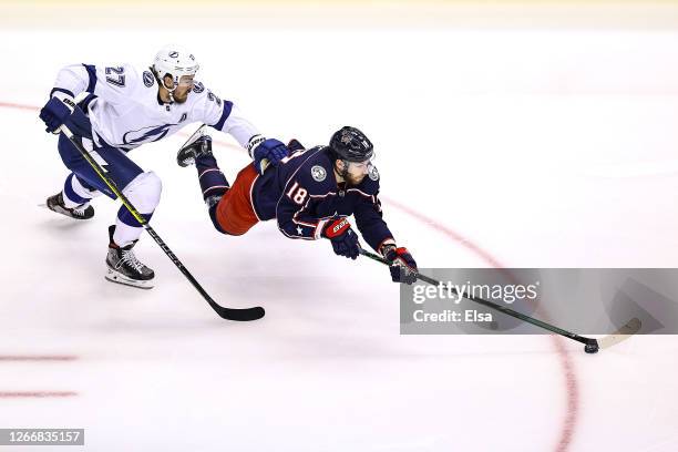 Pierre-Luc Dubois of the Columbus Blue Jackets gets tripped up against Ryan McDonagh of the Tampa Bay Lightning during the first period in Game Four...