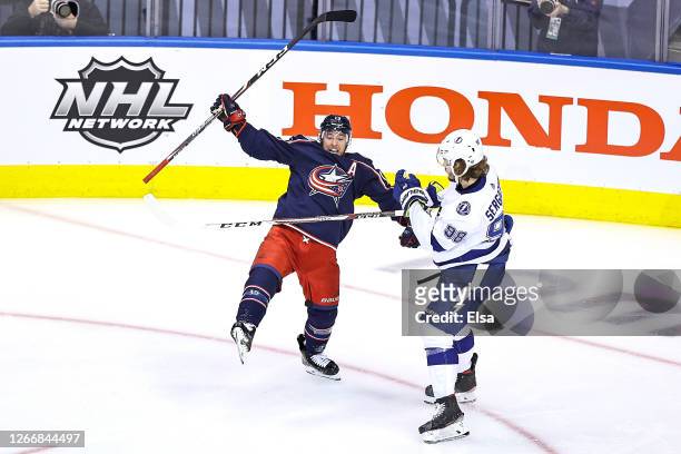 Cam Atkinson of the Columbus Blue Jackets is hit by Mikhail Sergachev of the Tampa Bay Lightning as he celebrates after scoring a goal during the...