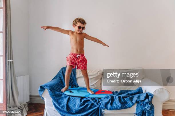 jongens die spelen aangezien zij bij het strand tijdens quarantaine zijn - zwemvliezen stockfoto's en -beelden