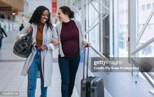 pregnant woman traveling by plane with female companion - family and happiness and diverse stock pictures, royalty-free photos & images