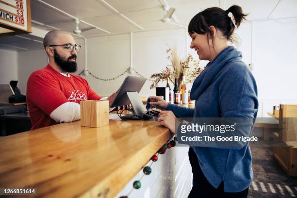 woman paying with credit card in pizzeria - american pizza stock pictures, royalty-free photos & images