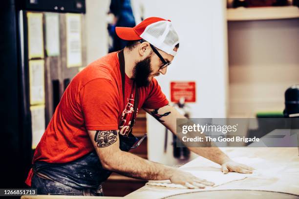 chef preparing pizza in kitchen - boné - fotografias e filmes do acervo