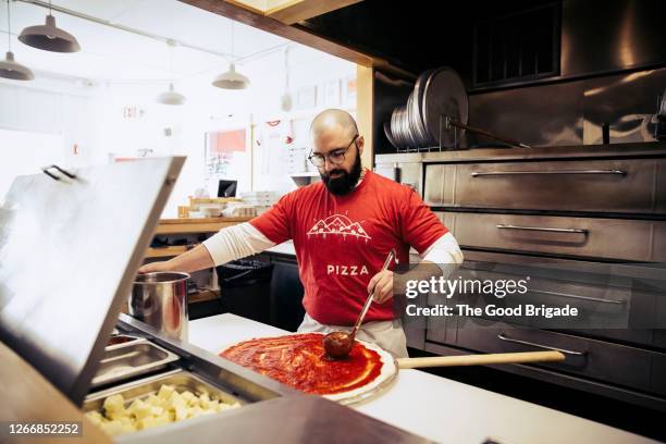 chef preparing pizza in kitchen - pizzeria - fotografias e filmes do acervo