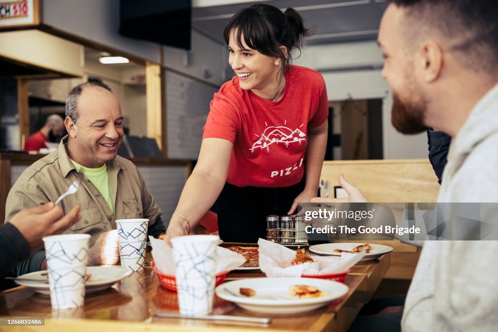 Waitress clearing plates from table at restuarant
