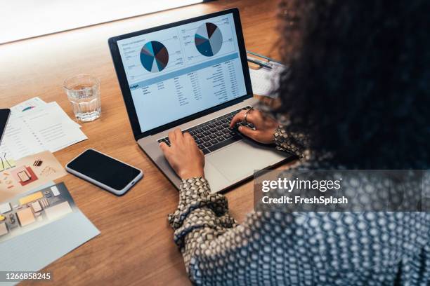 anonyme geschäftsfrau analysiert statistische geschäftsberichte auf ihrem laptop-pc im büro, eine nahaufnahme - data collection stock-fotos und bilder