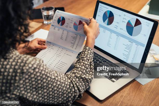 anonieme onderneemster die statistische bedrijfsrapporten op haar laptoppc bij het bureau analyseert, een close up - data collection stockfoto's en -beelden