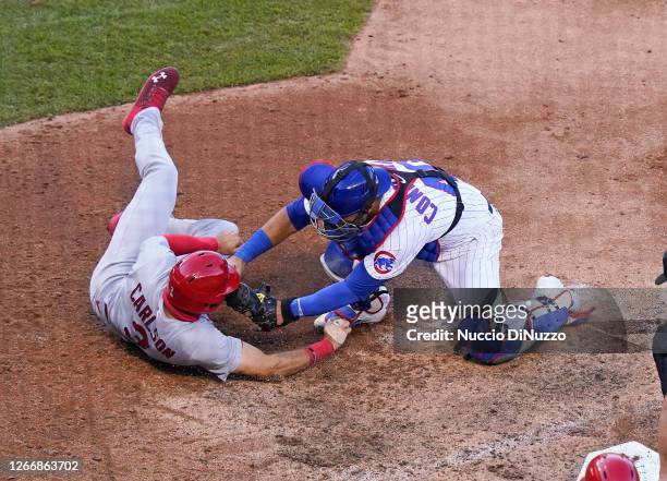 Dylan Carlson of the St. Louis Cardinals is tagged out at home by Willson Contreras of the Chicago Cubs during the seventh inning of a game of Game...