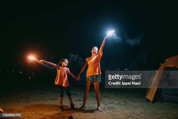 children playing with sparklers at night - japan 12 years girl stock pictures, royalty-free photos & images