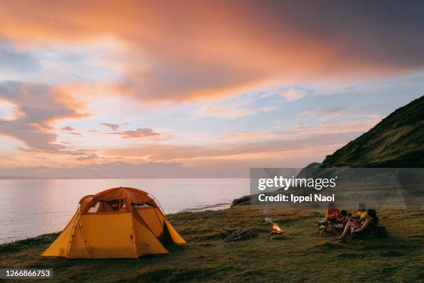 family camping by the sea at sunset - camp site foto e immagini stock