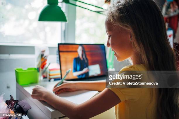 schoolgirl studying with video online lesson at home. - remote location stock pictures, royalty-free photos & images