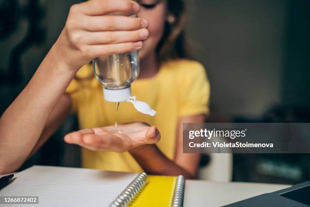 schoolmeisje dat handen met het desinfecteren antibacteriële gel schoonmaakt. - handdesinfectiemiddel stockfoto's en -beelden