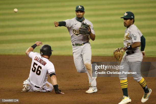 Infielder Marcus Semien of the Oakland Athletics throws over the sliding Kole Calhoun of the Arizona Diamondbacks to complete a double play during...