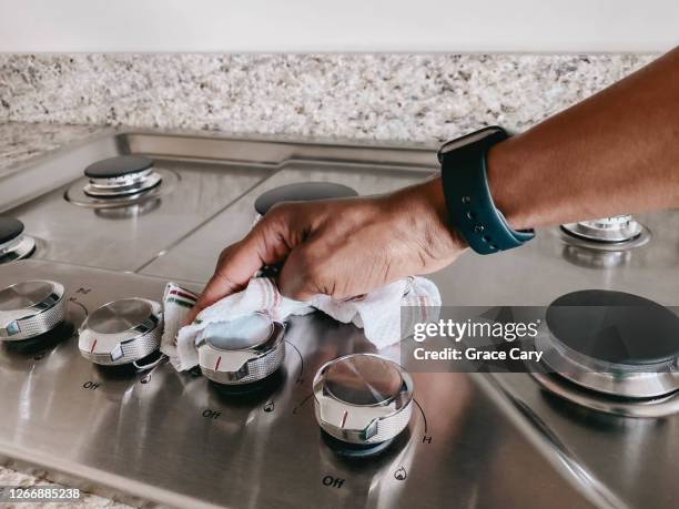 woman wipes cooktop - cleaning kitchen stock pictures, royalty-free photos & images