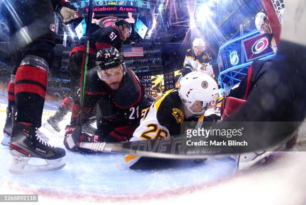 Nino Niederreiter of the Carolina Hurricanes falls in the net with Par Lindholm of the Boston Bruins during the third period of Game Four of the...