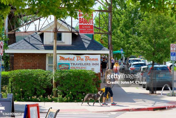 woman walks dog past historic motel du beau, flagstaff, arizona - flagstaff arizona stock pictures, royalty-free photos & images